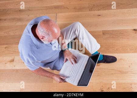 Man in his 70s getting to grips with technology. Stock Photo