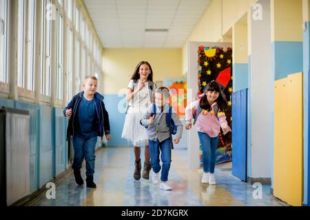 Group of children running through the hall of a school Stock Photo