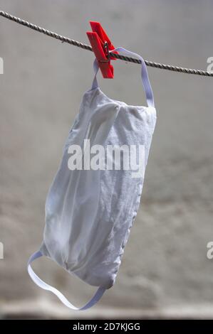 Close-up of a white hygienic mask stretched out to dry from the heat of the sun and wind. Homemade Mask Stock Photo