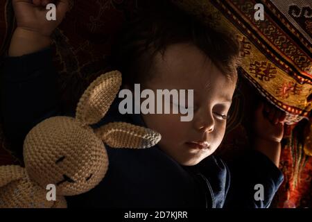 Baby boy sleeping with his bunny doll. Stock Photo