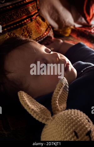 Baby boy sleeping with his bunny doll. Stock Photo