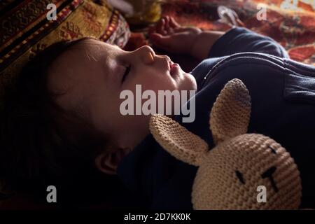 Baby boy sleeping with his bunny doll. Stock Photo