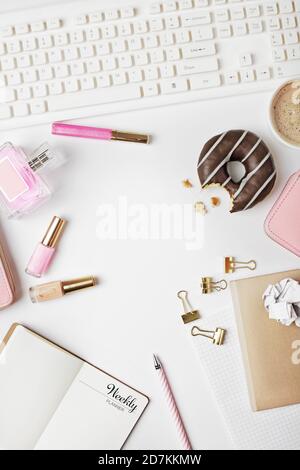 blogger or freelancer workspace with weekly planner, notebook, laptop, coffee and female fashion accessories on white background. Flat lay, top view o Stock Photo