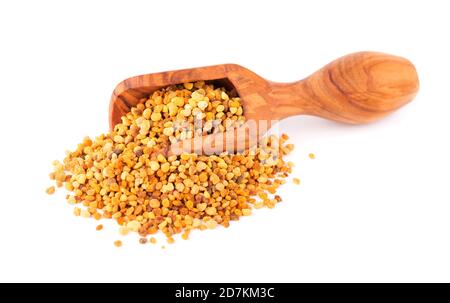 Flower pollen grains in wooden scoop, isolated on white background. Pile of bee pollen or perga. Stock Photo