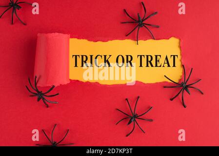 Top above overhead view photo of torn halloween red paper over yellow background with decorative spiders Stock Photo