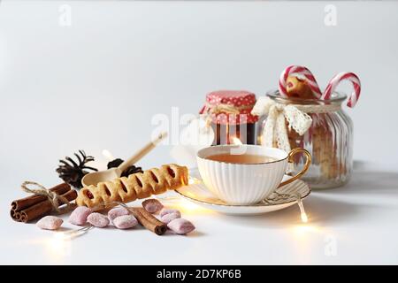 Tea with pastries for breakfast. Sweets and pastries with nuts for tea on a white background. A coffee cup and patties. Stock Photo