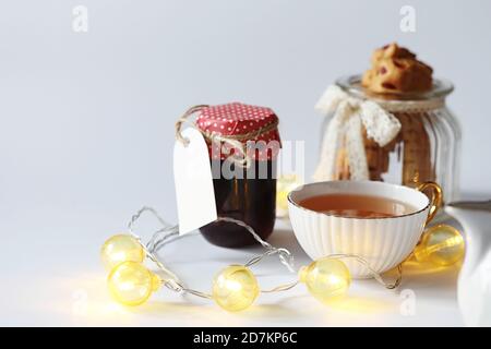 Tea with pastries for breakfast. Sweets and pastries with nuts for tea on a white background. A coffee cup and patties. Stock Photo