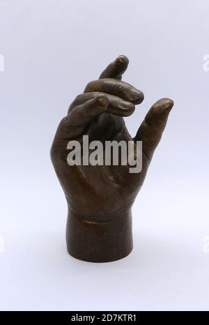 Photo of a Child's hand sculpture cast in bronze and strongly lit against a white background Stock Photo