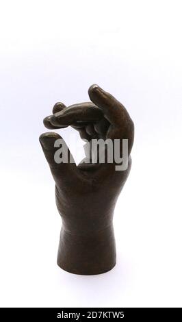 Photo of a Child's hand sculpture cast in bronze and strongly lit against a white background Stock Photo