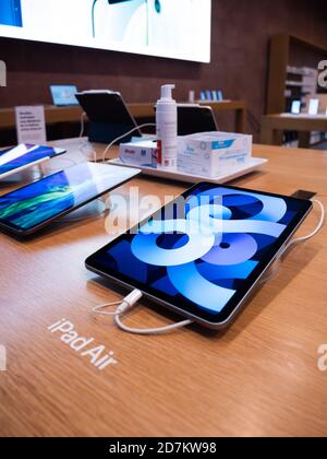 Paris, France - Oct 23, 2020: Side view of Apple Computers iPad Air new tablet with large retina display with hand sanitizier and desinfectant for COVID-19 pandemic on wooden table Stock Photo