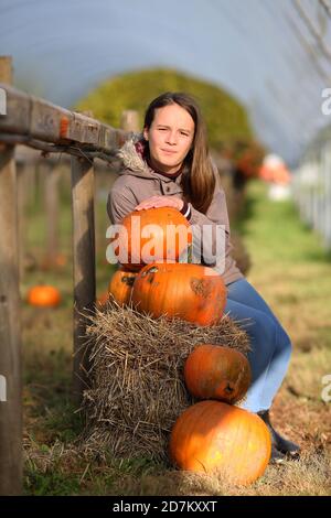 A young girl poses with some pumpkins after collecting them for Halloween in the Brecon Beacons, Wales. ©PRWPhotography Stock Photo