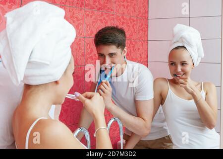 A young couple is brushing teeth. Couple fooling around in the bathroom. Lifestyle photography Stock Photo