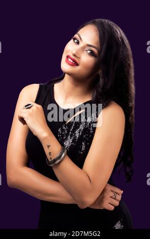 Portrait of beautiful indian girl in black colour fashion posses on dark background Stock Photo