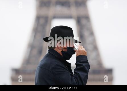 Paris, France. 23rd Oct, 2020. A man wearing a face mask walks past the Trocadero Place near the Eiffel Tower in Paris, France, Oct. 23, 2020. With a record 42,032 new infections confirmed in the last 24 hours, France has counted an accumulative total of 1,041,075 COVID-19 cases as of Friday, becoming the second European Union (EU) country passing the grim one-million mark after Spain. Credit: Gao Jing/Xinhua/Alamy Live News Stock Photo