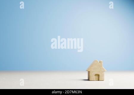 Home sweet home, house wood with heart shape on wooden and blue background, copy space. Stock Photo