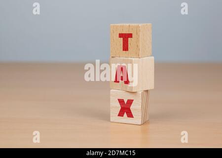 Businessman made word TAX with wood building blocks. Stock Photo