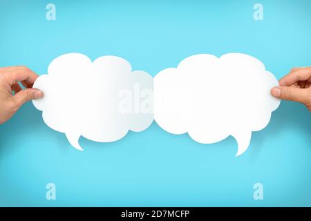 Two hands holding up speech bubbles Stock Photo