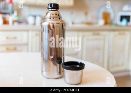 Close-up of steel thermos on white kitchen table Stock Photo