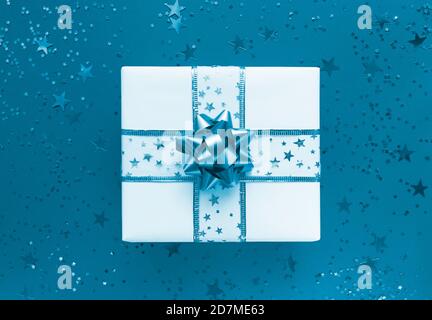 Gift box and stars on a blue background. Monochrome flat lay. Stock Photo