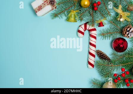 Christmas composition of Christmas toys, candy and spruce branches on a blue background. space for text. Stock Photo