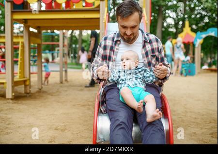 Happy parents play with little baby on playground Stock Photo