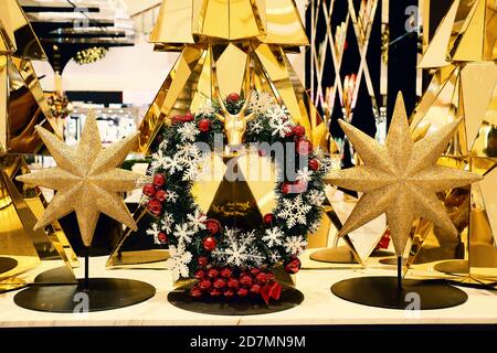 a elegant christmas wreath decorated with snowflakes and red balls is surrounding with golden stars and chrismas tree Stock Photo