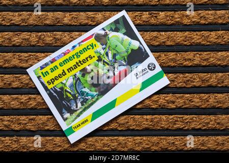 Post mail on doormat - appeal from St John Ambulance, in an emergency speed matters Stock Photo