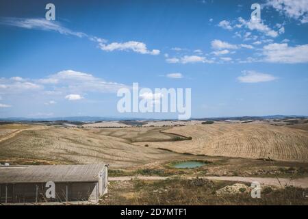 Dirt road in toscane in Italie through the fresh cut grain fields Stock Photo