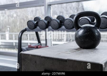 Gira and dumbbells in the back, the window shines bright sun in the black light background large on the wooden box Stock Photo