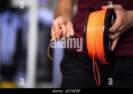 3D Printer Plastic filament for 3D printer and printed products in the hands of a young man Stock Photo