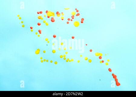 Random color oil paint splashes on blue paper. Stock Photo
