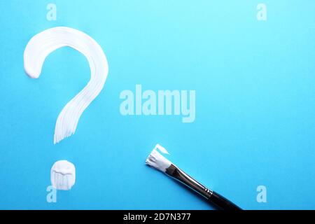 Question mark painted on a blue background. Stock Photo