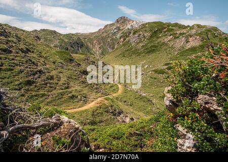 Little footpath surrounded by mountains in Somiedo Natural Park Stock Photo