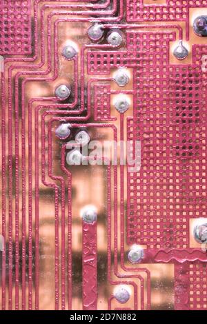 Electronic printed circuit board background with many electrical components, hardware. Red color, vertical image Stock Photo