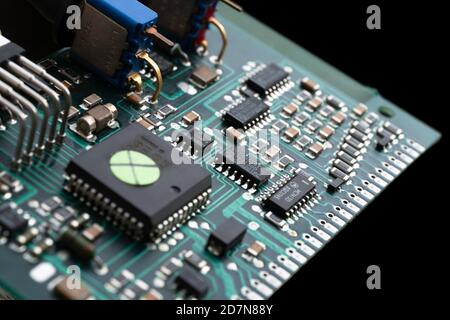 Electronic circuit board with many electrical components, isolated on black background Stock Photo