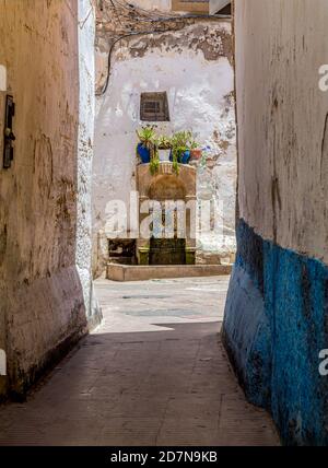 Typical narrow street with Moroccan mosaic decoration drinking fountain in the Medina of Essaouria,Morocco. Stock Photo