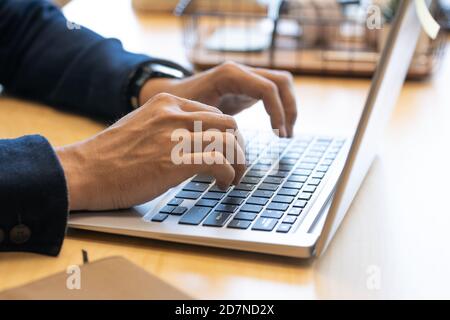 Hands of young contemporary male office manager over keys of laptop keypad Stock Photo