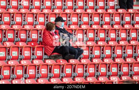 24 October 2020, Berlin: Football: Bundesliga, 1st FC Union Berlin - SC Freiburg, 5th matchday, Stadion An der Alten Försterei. Two spectators sit between deserted seats in the stadium wearing face masks. Entering the stadium is currently only permitted under permanent wearing of a mouth and nose cover. Allowed seats are marked green on the underside. Photo: Andreas Gora/dpa-Pool/dpa - IMPORTANT NOTE: In accordance with the regulations of the DFL Deutsche Fußball Liga and the DFB Deutscher Fußball-Bund, it is prohibited to exploit or have exploited in the stadium and/or from the game taken pho Stock Photo