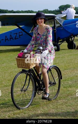 Woman Riding Vintage Bicycle at Shuttleworth Collection Air Display, , Old Warden, England, United Kingdom, Stock Photo