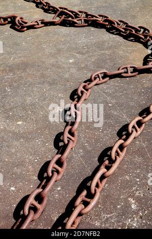 Rusty anchor chain on concrete pier Stock Photo