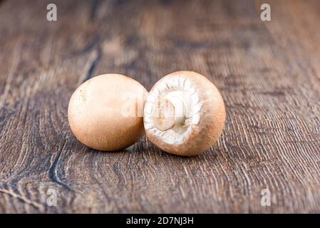 Two fresh brown mushrooms champignons on wooden table. Close up. Copy space. Stock Photo