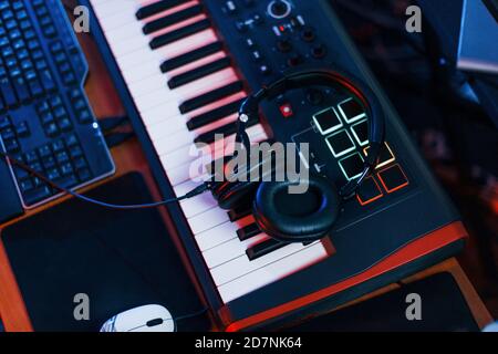 Close up view of headphones that lying down on the keyboard in the studio Stock Photo
