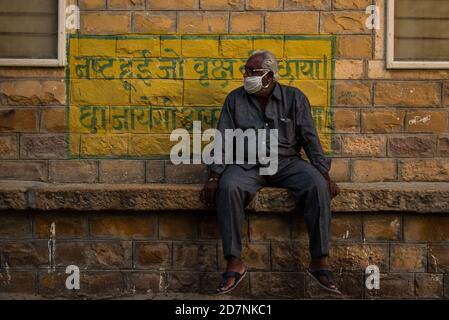 Jaisalmer, Rajasthan / India - september 24 2020 : Old man sitting and maintaining social distancing guidelines waiting for pick up Stock Photo