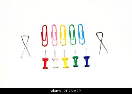 Push pins and paper clips in different colors isolated on white background. Stock Photo