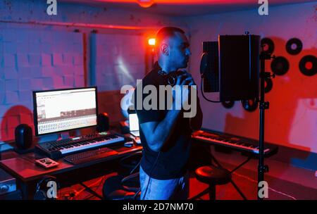 Vocalist have recording session indoors in the modern professional studio Stock Photo