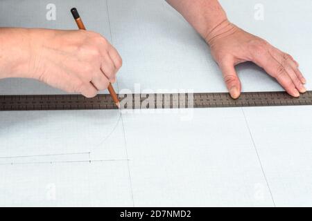 Woman tailor draw dress pattern on paper and participate in creating ...
