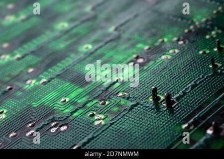 Green electronic circuit board with many electrical components. Narrow depth of field, focus on the right part of the image Stock Photo