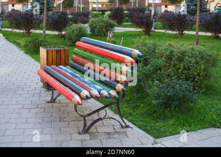 Creative multi colored wooden bench made of boards stylized as colour pencils in public park. Stock Photo
