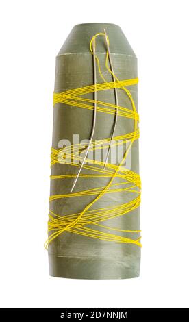 plastic bobbin with last yellow thread and two sewing needles cutout on white background Stock Photo