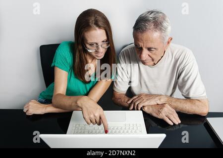 Woman helping father with laptop Stock Photo